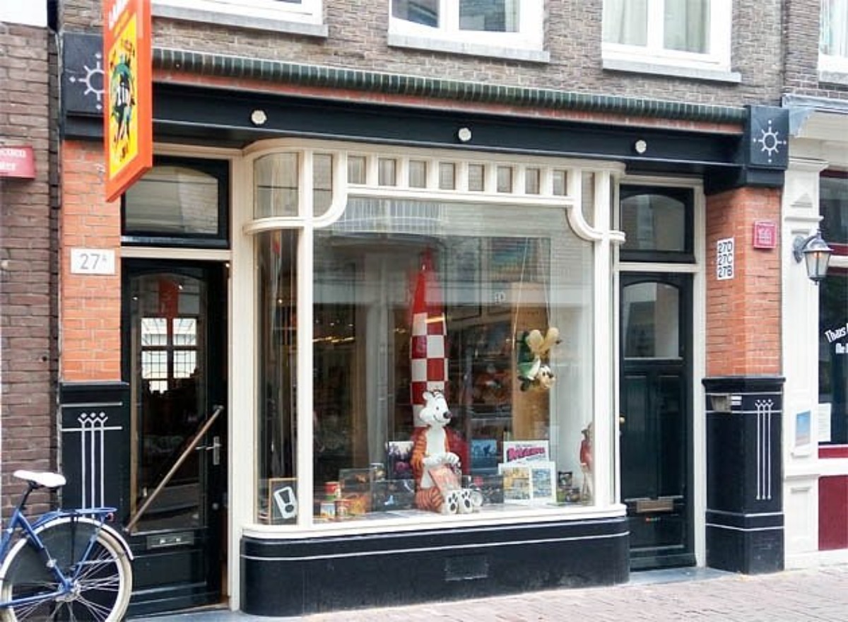 Toy shop storefront among shops in Amsterdam with vintage brick facade.