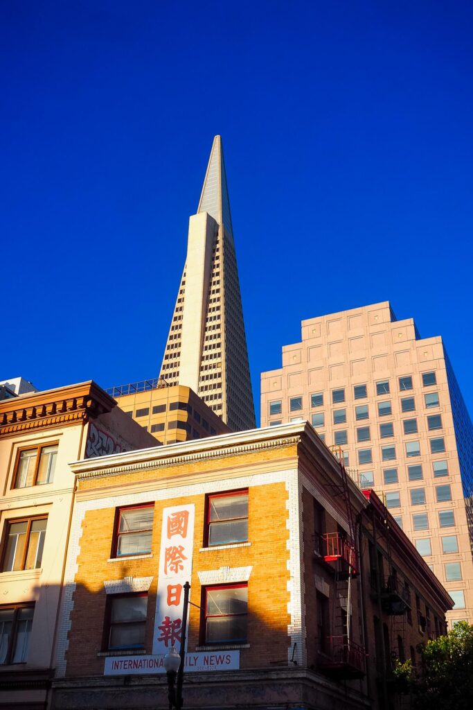 Transamerica Pyramid and historic Chinese architecture against a vibrant blue sky in San Francisco.