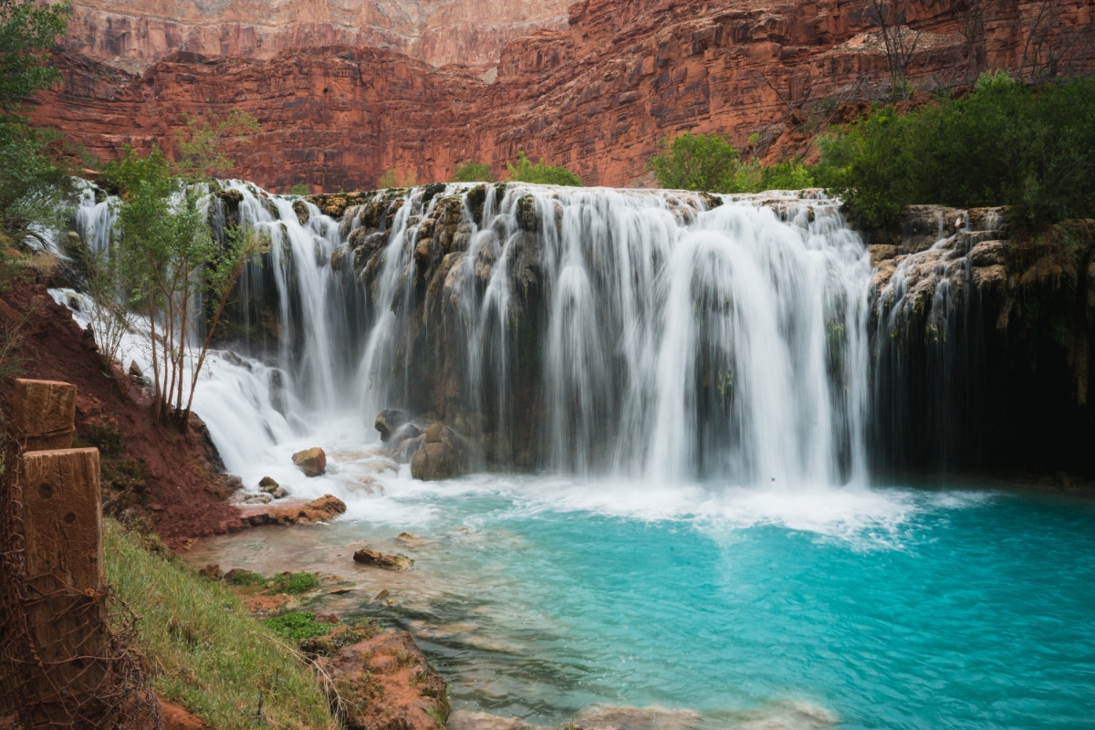 Lower Navajo Falls   Turquoise waterfall streams over red canyon sandstone into a turquoise pool in a canyon landscape.