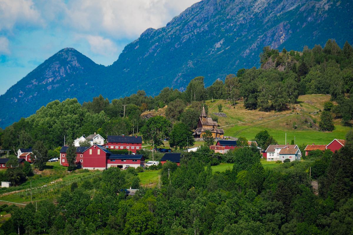 Urnes Stave Church in Luster, Norway surrounded by lush greenery and mountains