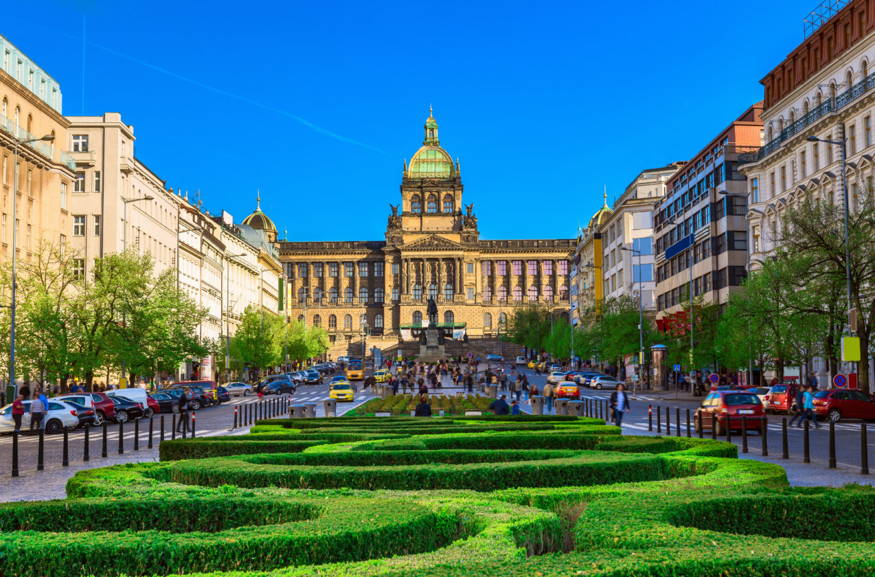 Wenceslas Square and Prague National Museum stand under a vivid blue sky, Czech Republic.