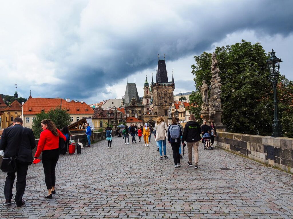 Charles Bridge in Prague, gothic statues, red rooftops, medieval charm