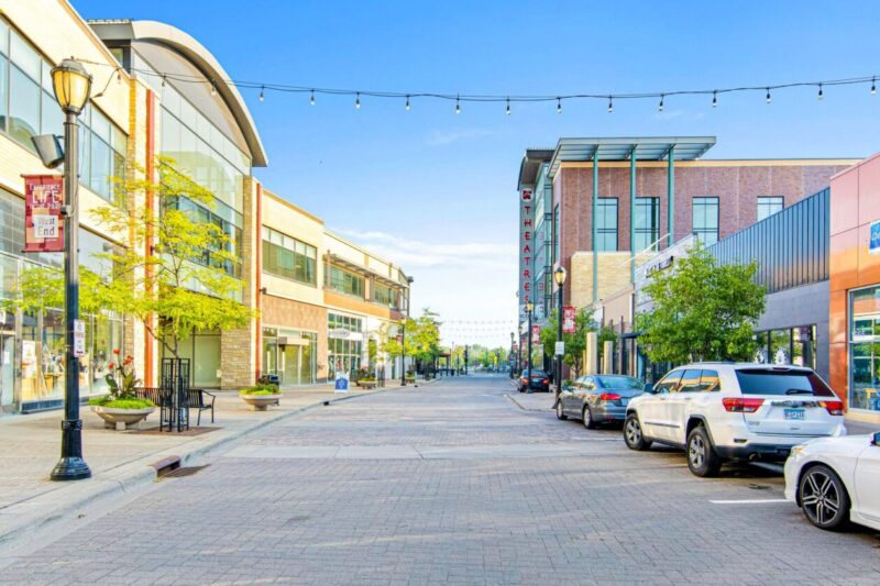 The Shops at West End St. Louis Park Street is a pedestrian-friendly street with glass storefronts, theaters, and string lights.