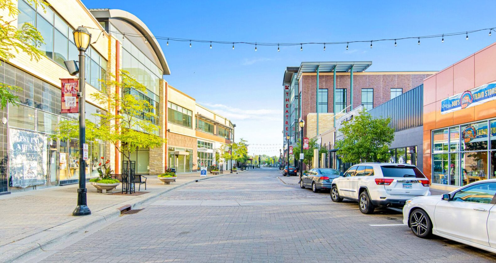 The Shops at West End St. Louis Park Street is a pedestrian-friendly street with glass storefronts, theaters, and string lights.