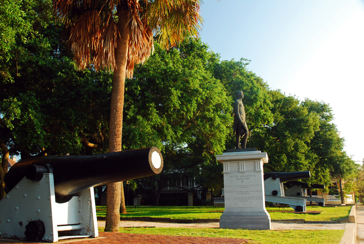 Historic cannon and monument beneath live oaks in White Point Garden