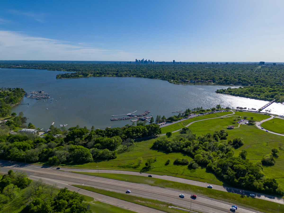 Dallas White Rock Lake Park and Dallas Skyline with highway traffic