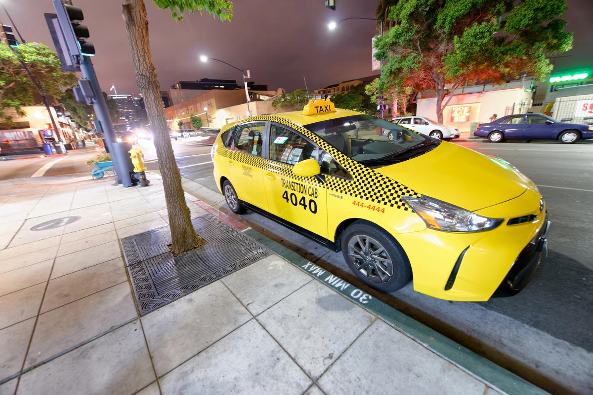 Yellow taxi cab parked on downtown San Diego street at night