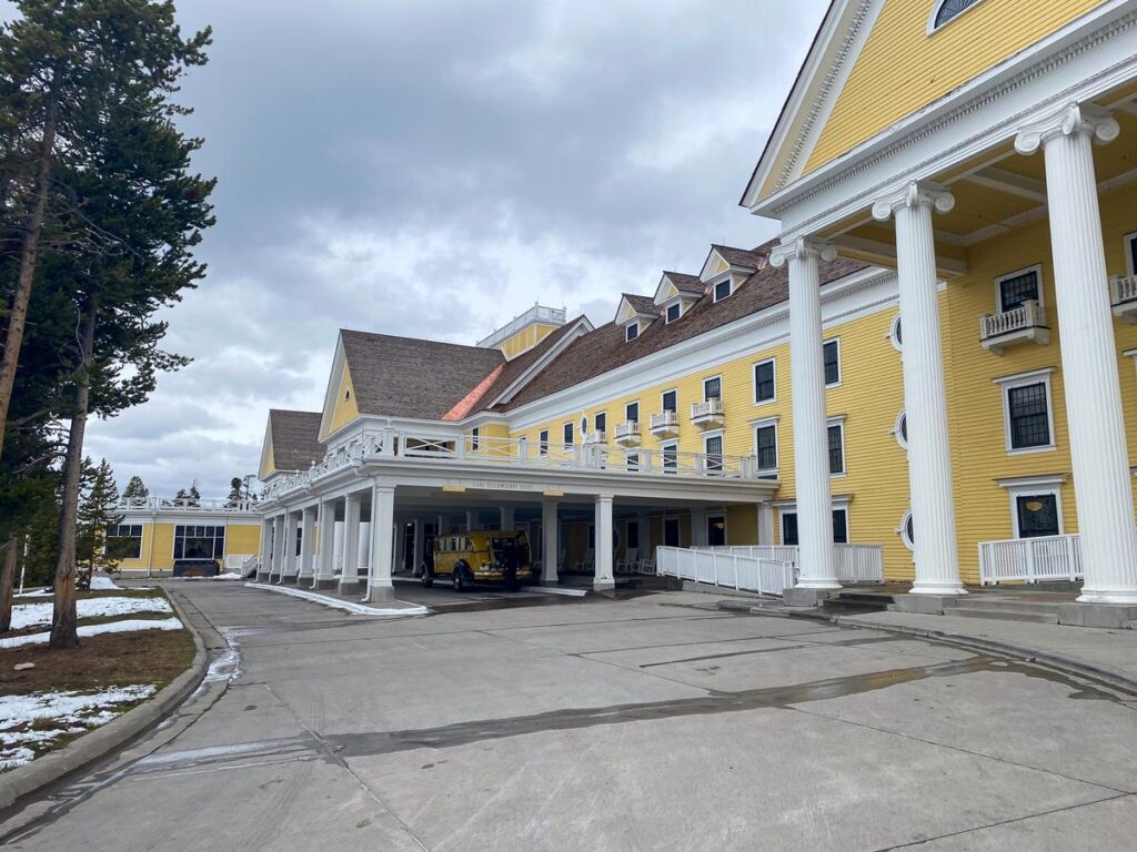 Lake Yellowstone Hotel entrance, historic yellow landmark in natural setting