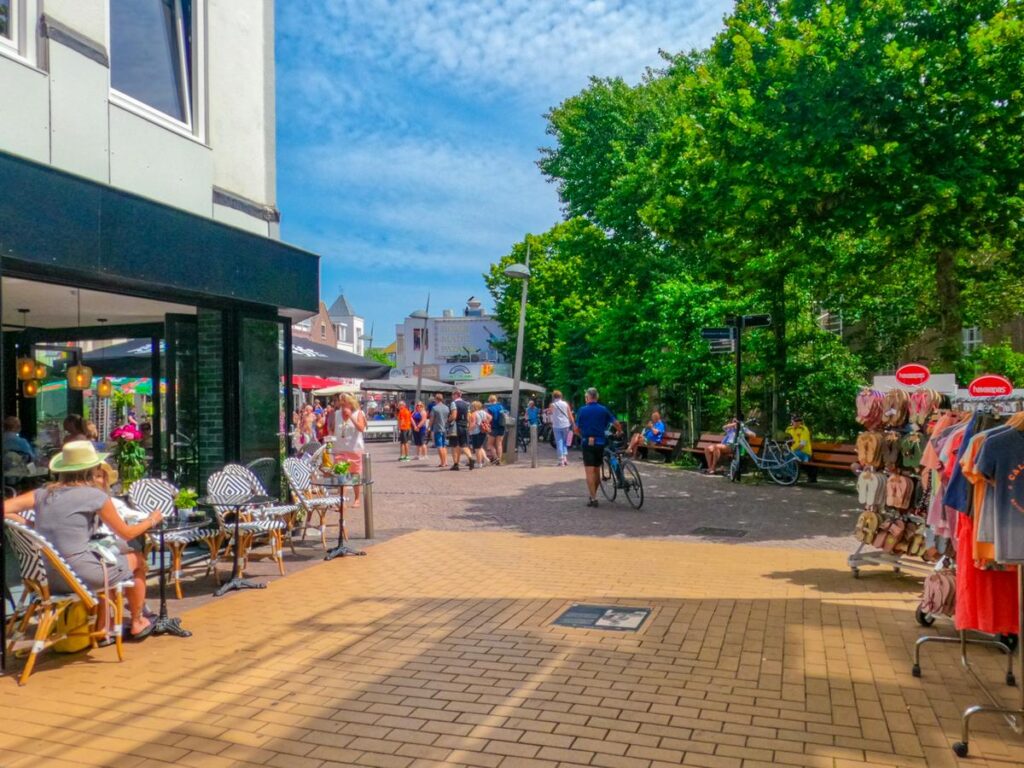 Bustling Zandvoort shopping district on a summer day with sidewalk café scene and boutique shopping.