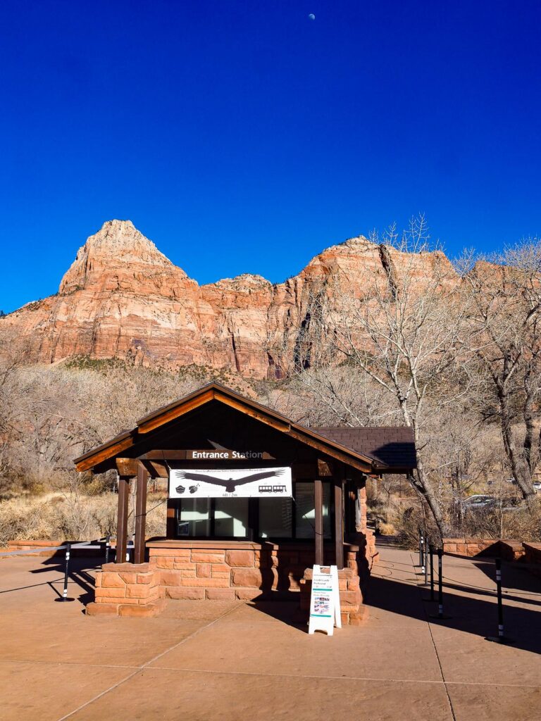 Zion National Park Entrance with Moonlit Sky, Red Cliffs, and Visitor Station