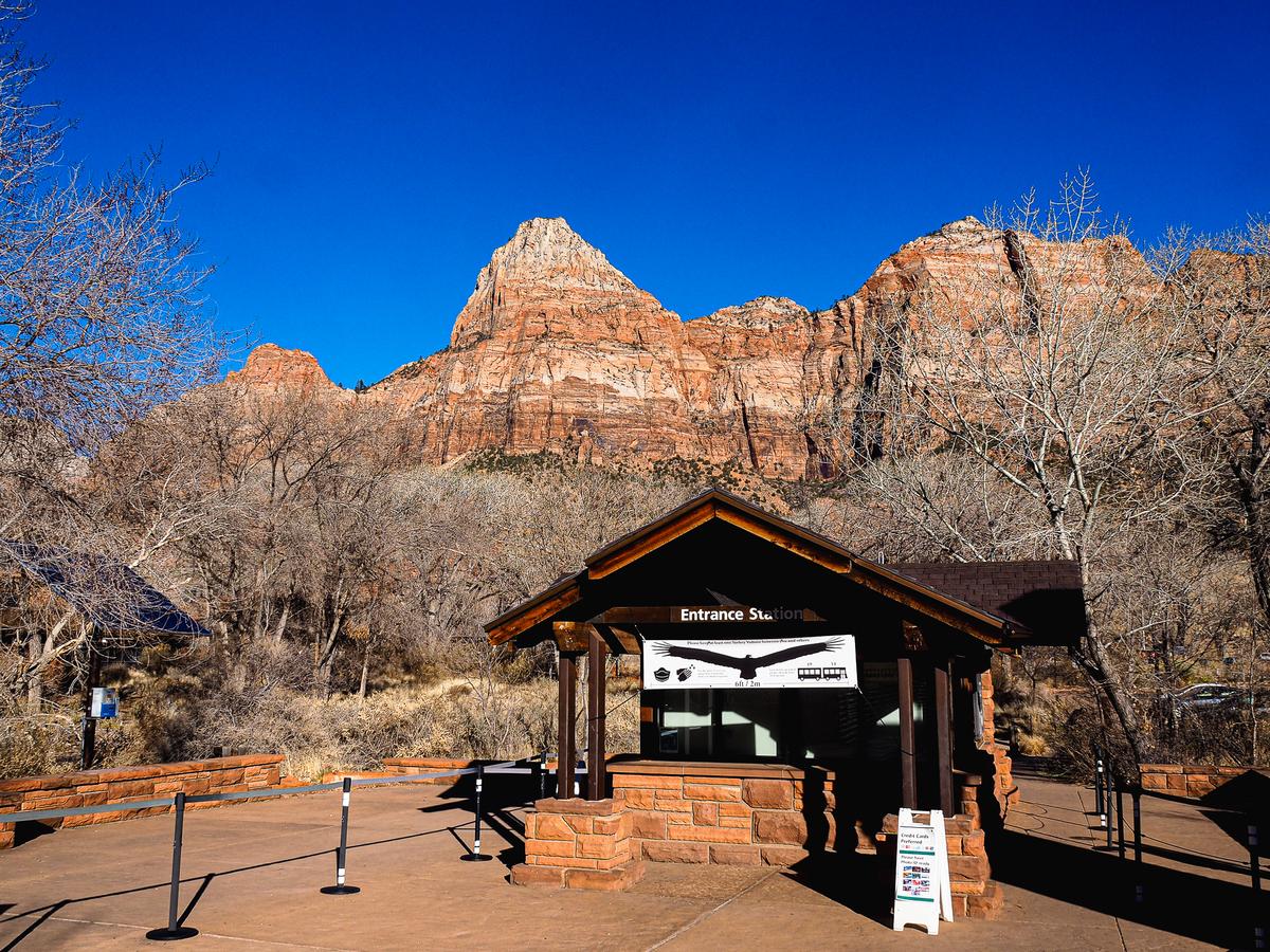 Zion National Park entrance station with red rock formations and blue sky